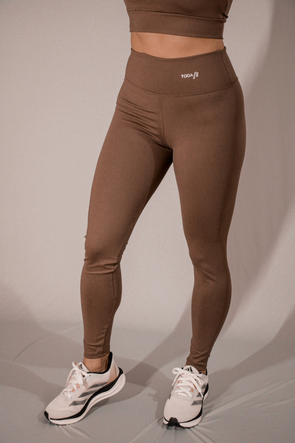 Legging básica chocolate TodaFit em visão lateral, destacando ajuste ao corpo.