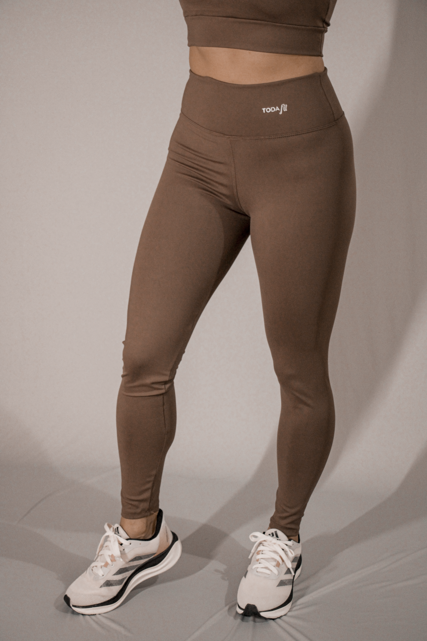 Legging básica chocolate TodaFit em visão lateral, destacando ajuste ao corpo.