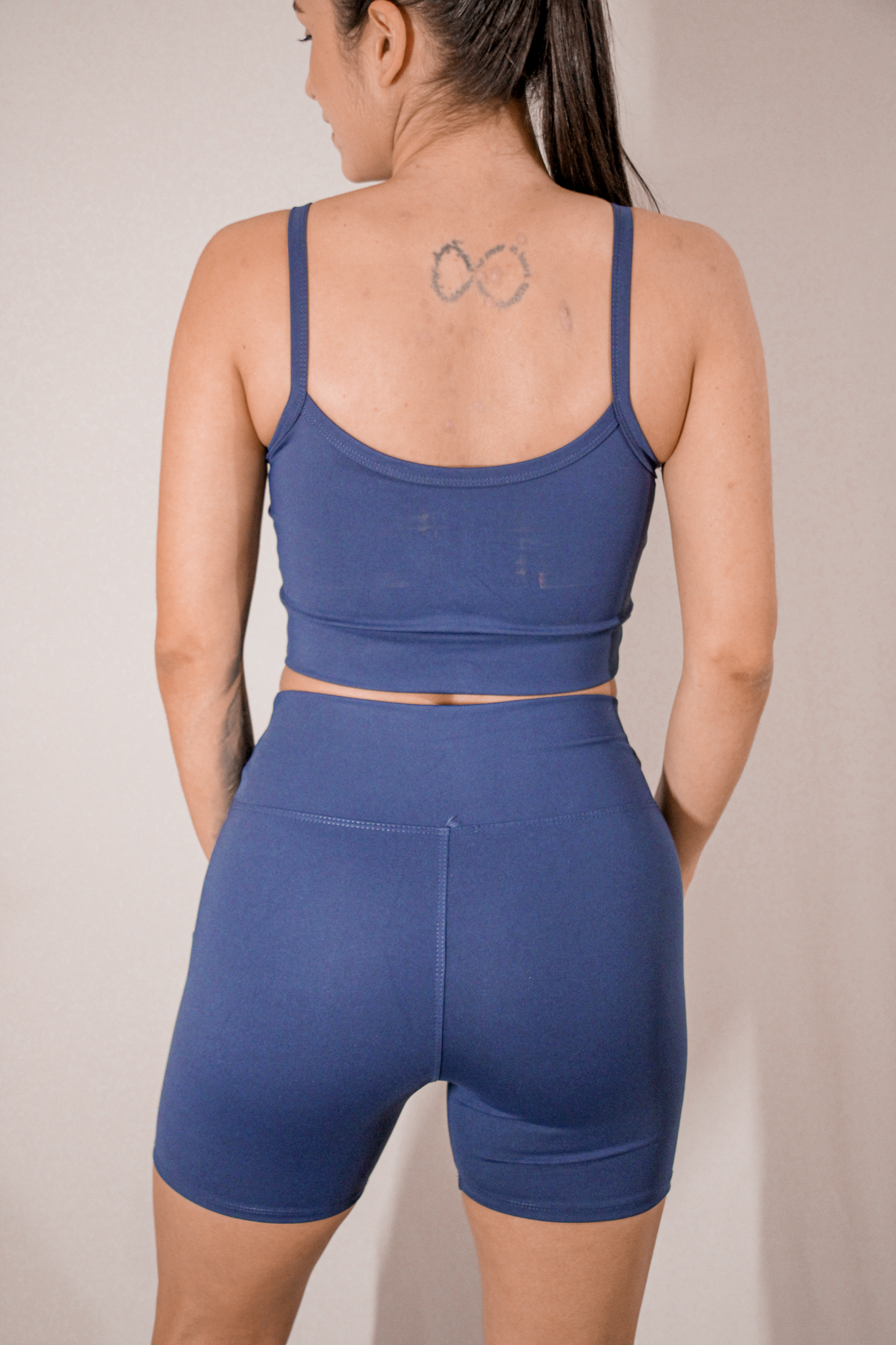 Short fitness sem bolso azul marinho TodaFit na visão posterior, mostrando acabamento reforçado e compressão firme.