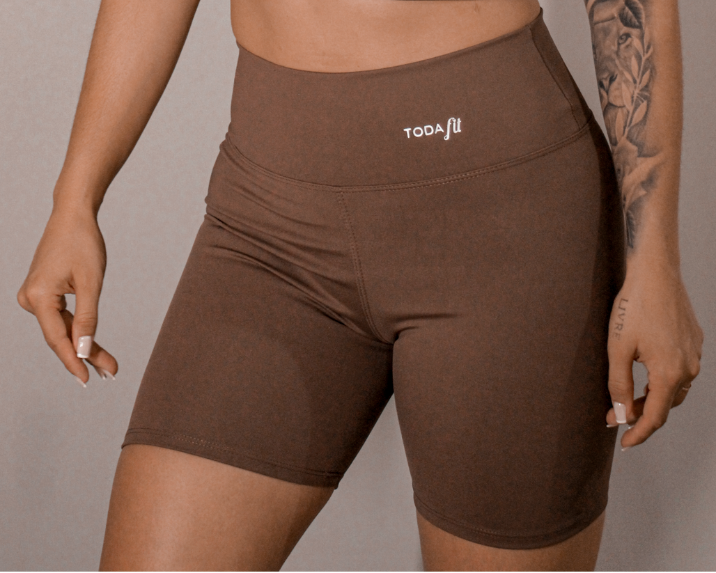 Detalhes do short fitness sem bolso chocolate TodaFit em close próximo, evidenciando textura do tecido e qualidade da costura.