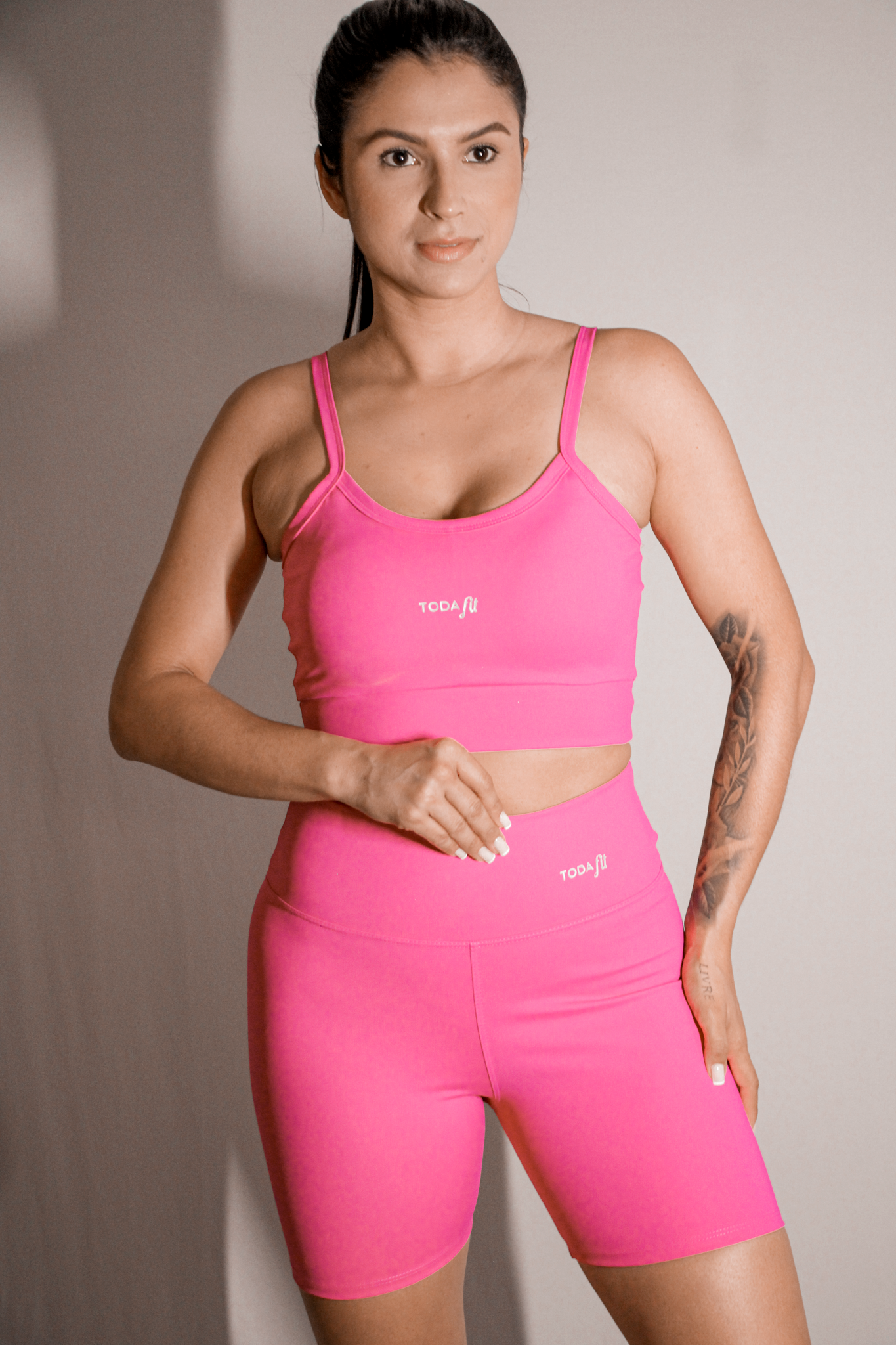 Short fitness sem bolso pink TodaFit na vista frontal de longe, mostrando o resultado de corpo inteiro, com modelagem justa e tecido de alta compressão.