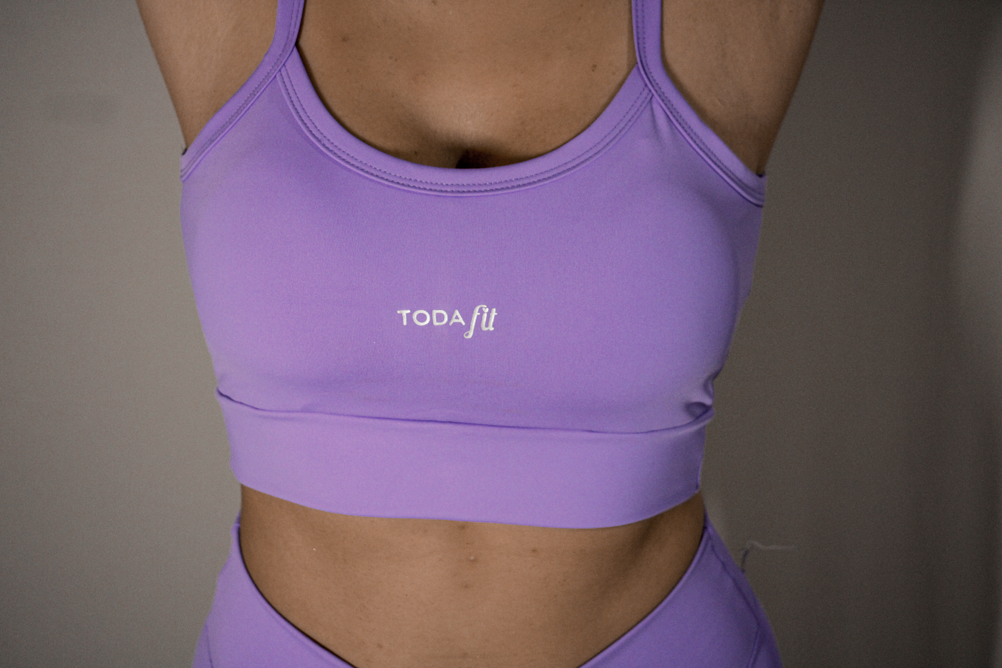 Detalhe do top slim lilas TodaFit em close, ressaltando textura e qualidade.